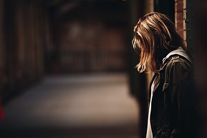 Home. Young woman hanging head